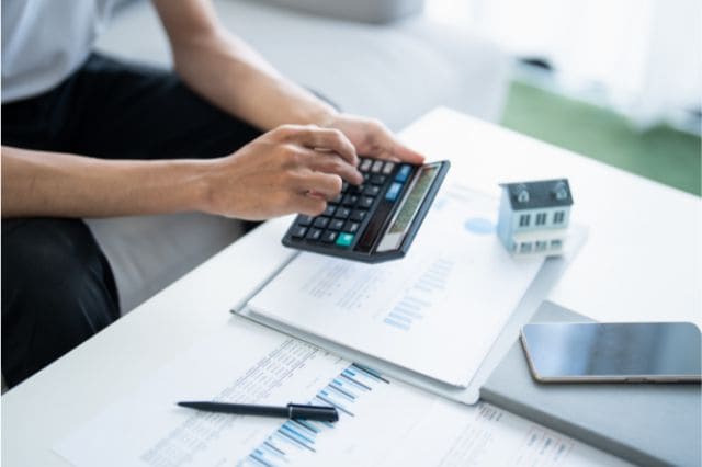 Das passende Preisbildungsmodell finden: Fehler, Tipps, Praxisbeispiele 2 Person berechnet Preis mit Taschenrechner